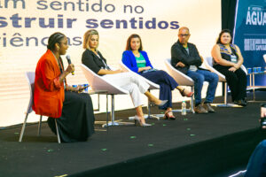 Convidados da edição de 2023 sentados no palco do evento