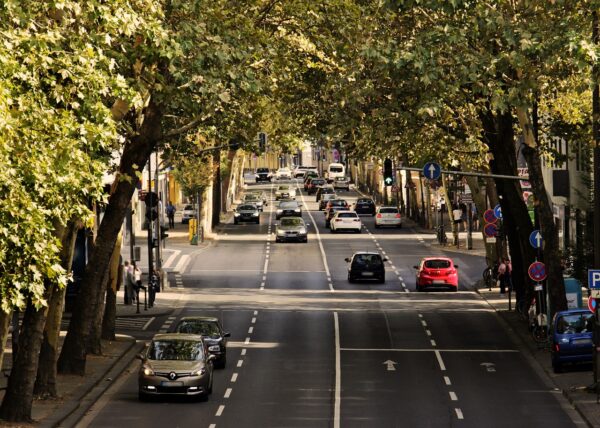 Trânsito em rua de cidade com carros e motos